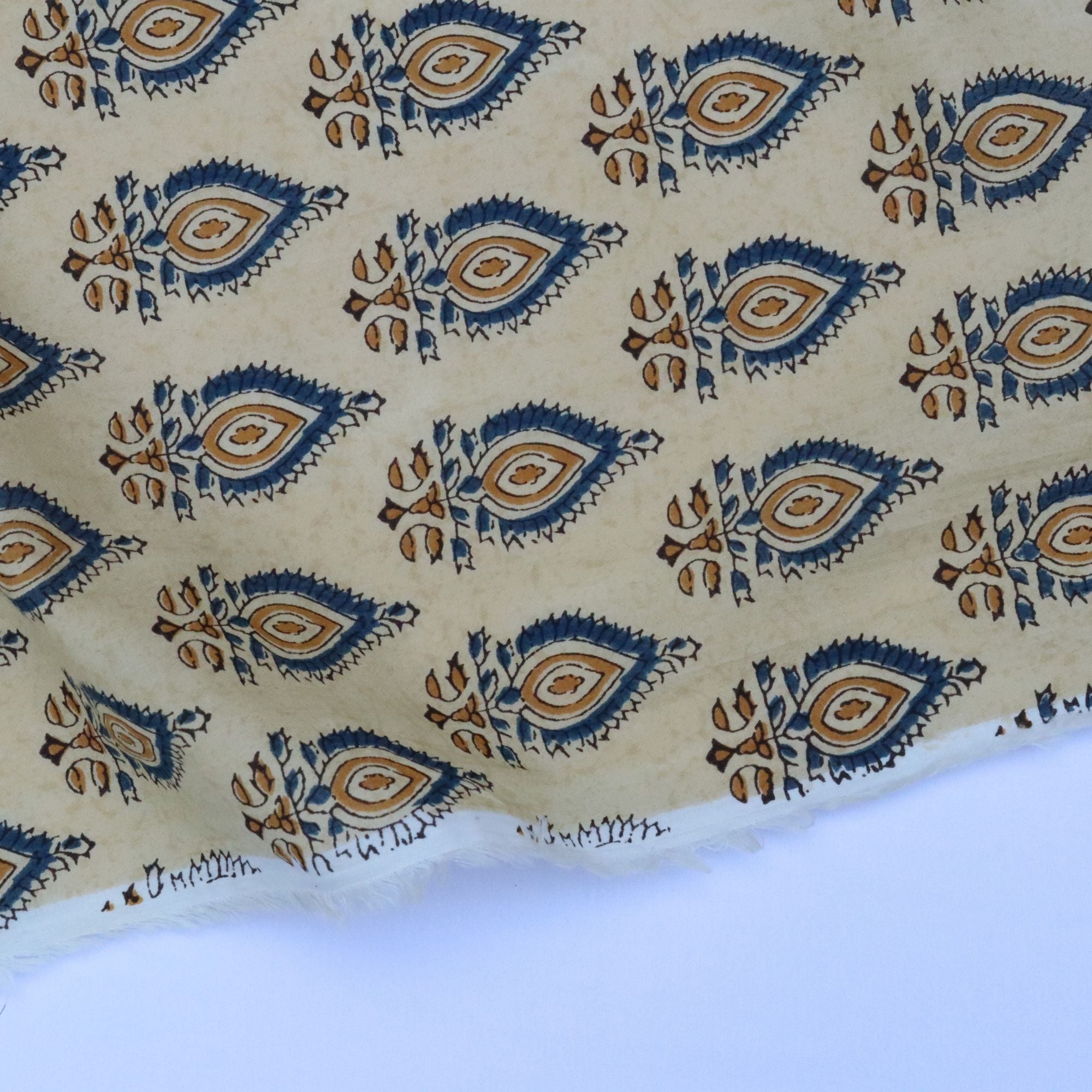 Patterned fabric with blue and brown designs on a beige background