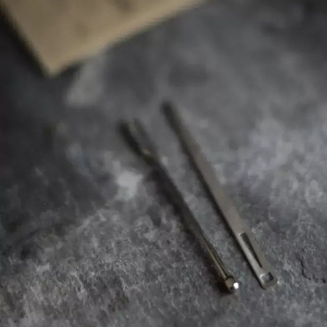 Two metal tools on a textured gray surface with a blurred background