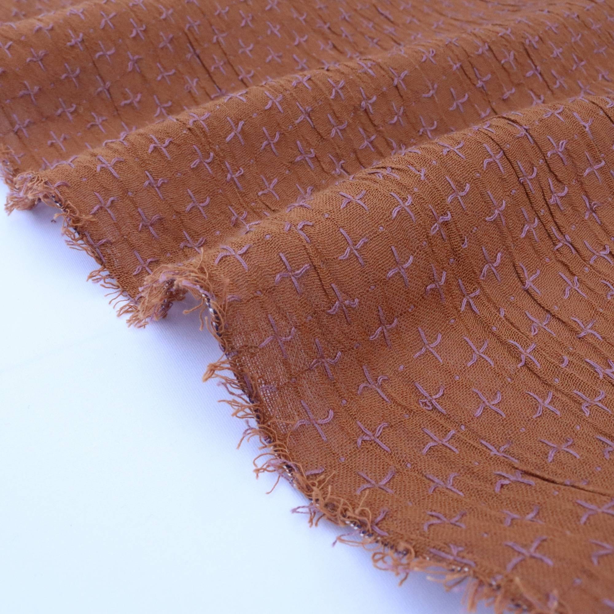 Brown fabric with a subtle pattern on a white background