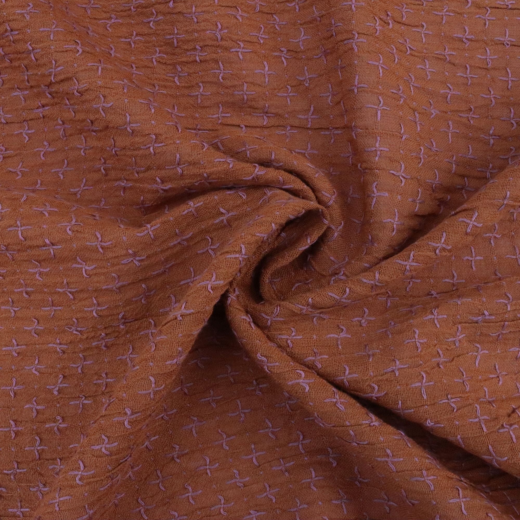Brown fabric with a subtle pattern, possibly of crosses or similar shapes.