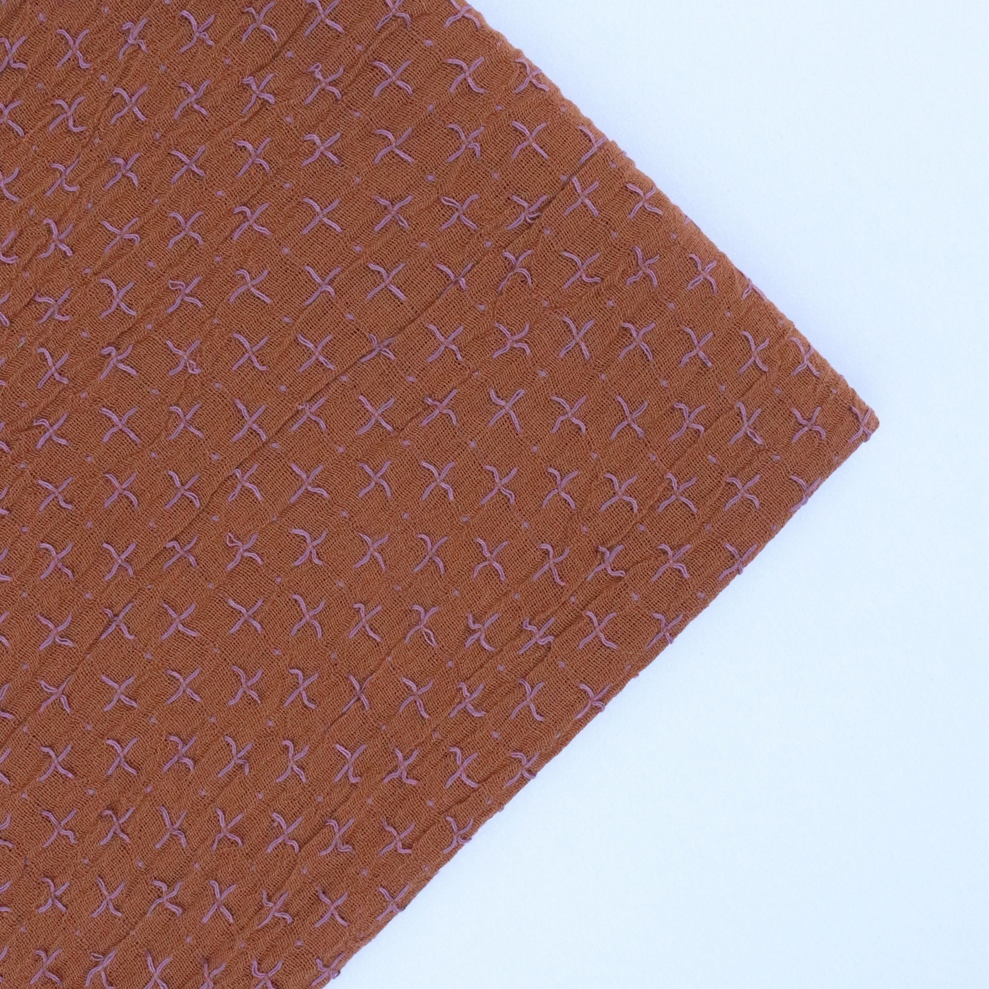 Brown fabric with a subtle pattern on a white background