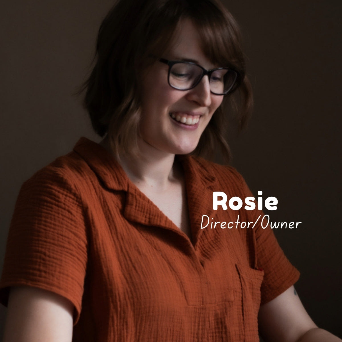 Woman wearing a rusty double gauze fabric top, smiling and looking down