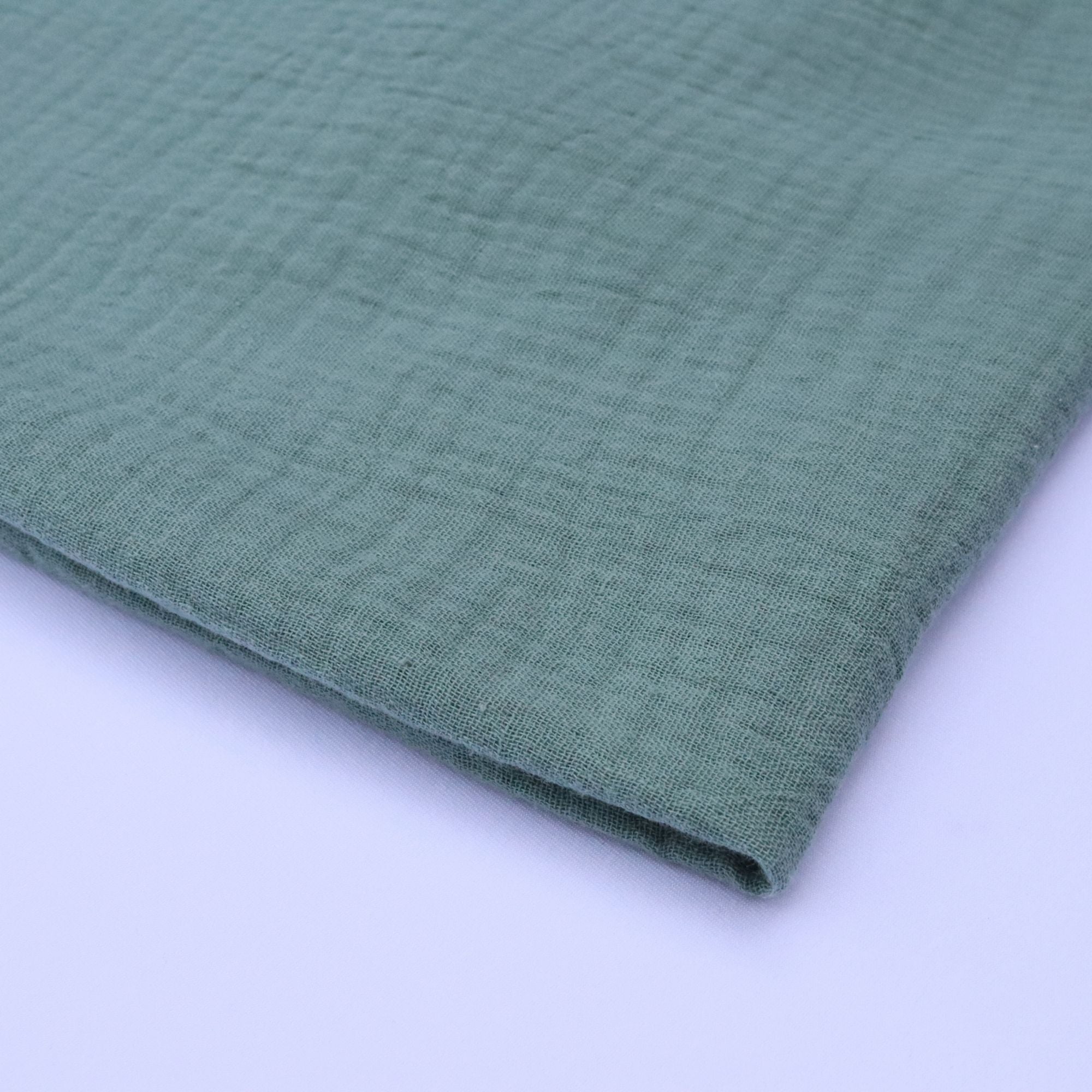 Close-up of green textured fabric on a white background
