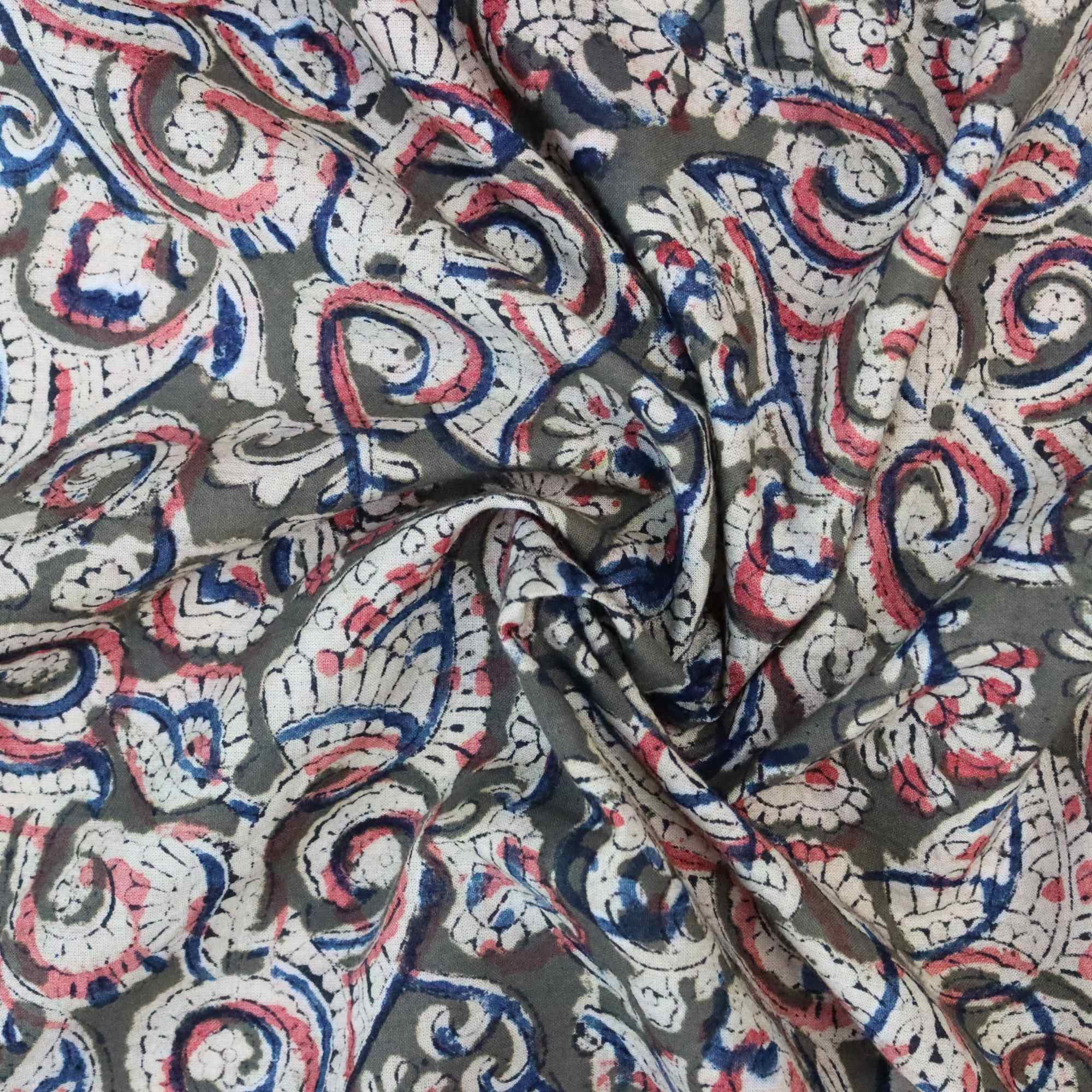 Close-up of patterned fabric with red, blue, and white swirls on a gray background