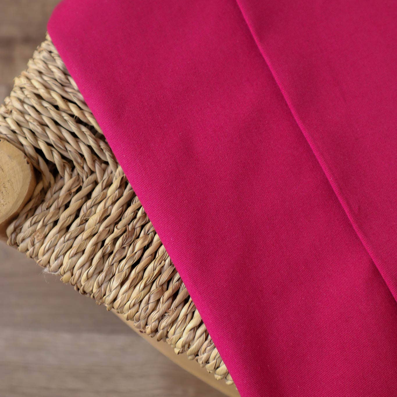 Super Pink Gabardine Cotton Fabric laying draped over a chair