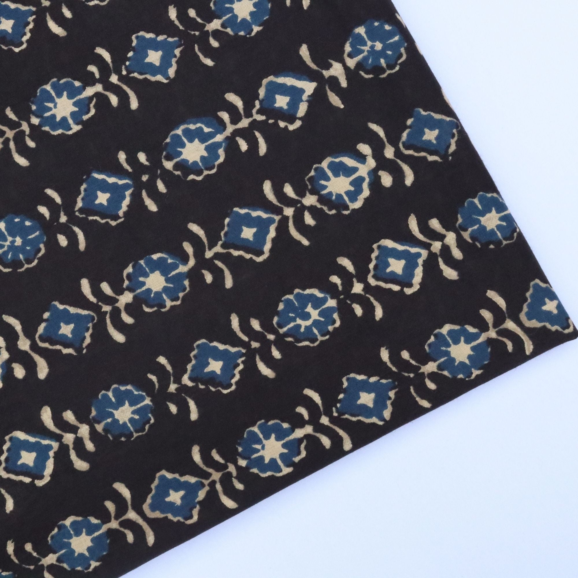 Black fabric with blue and beige floral pattern on a white background