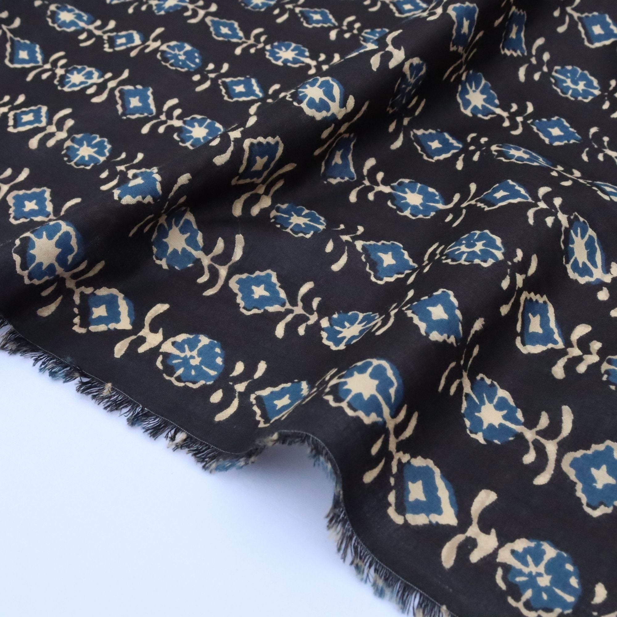 Black fabric with blue and beige pattern on a white background
