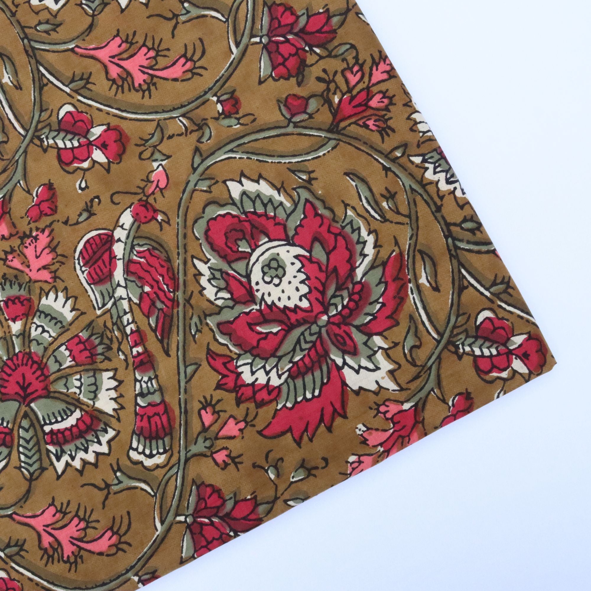 Floral patterned fabric with red and white flowers on a brown background