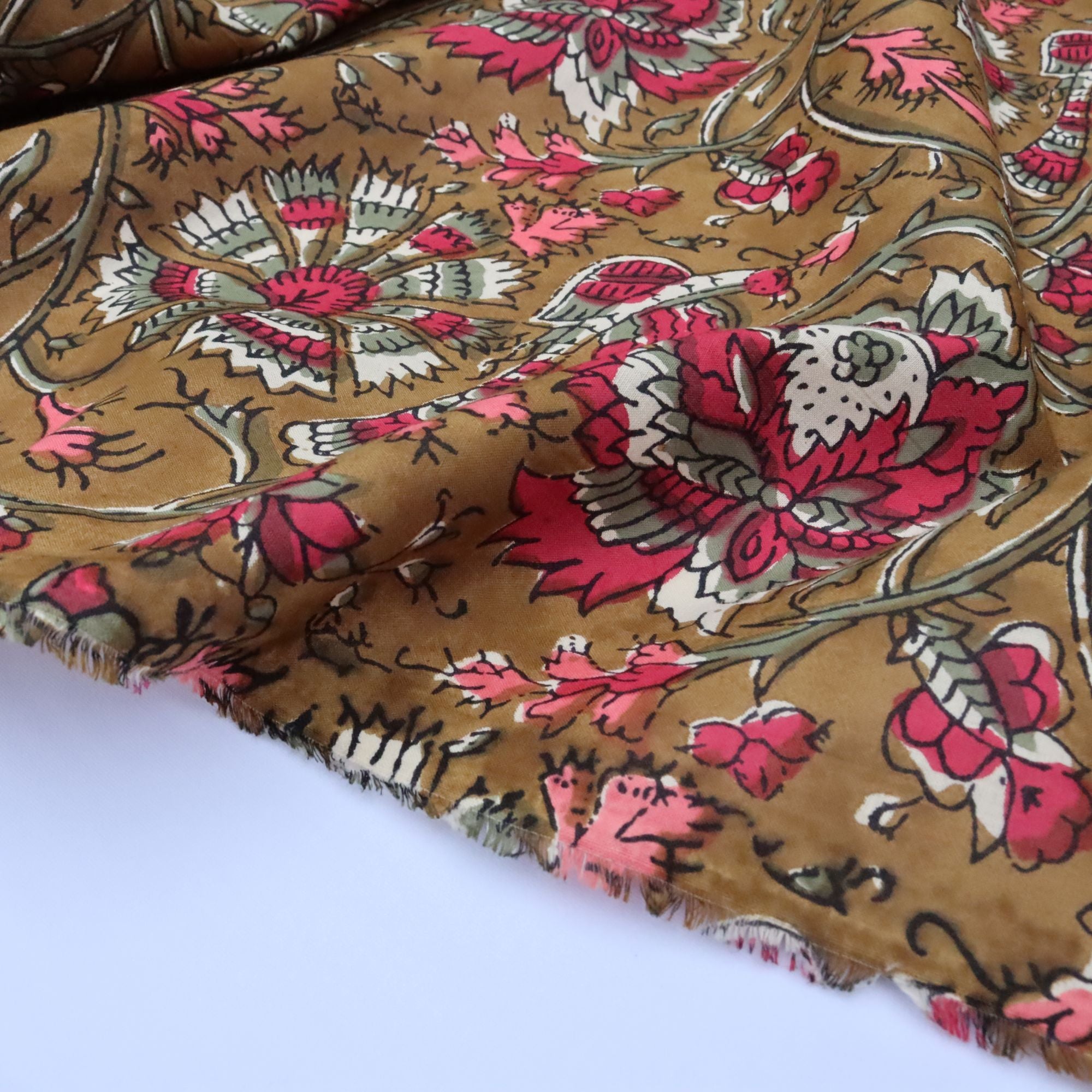 Floral patterned fabric with pink and white flowers on a brown background