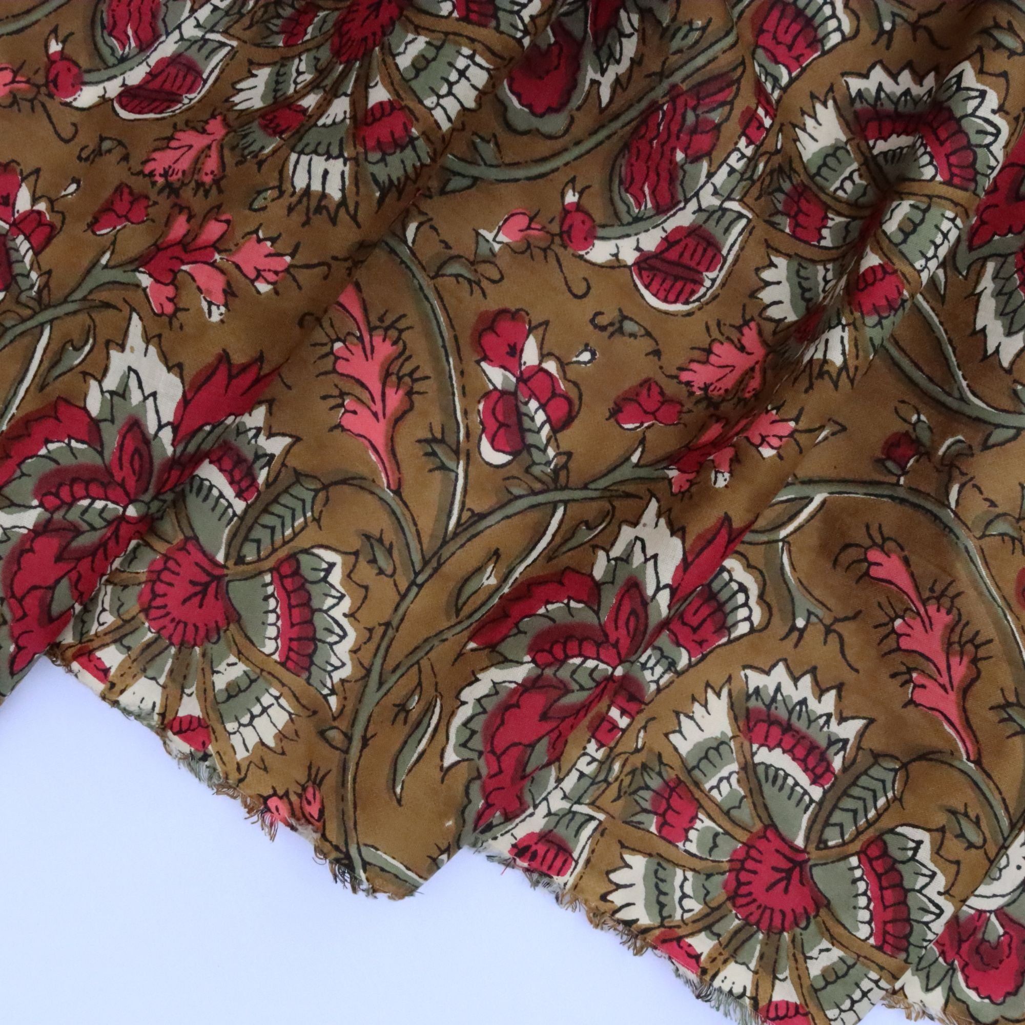 Close-up of floral fabric with red, white, and brown colors on a plain background