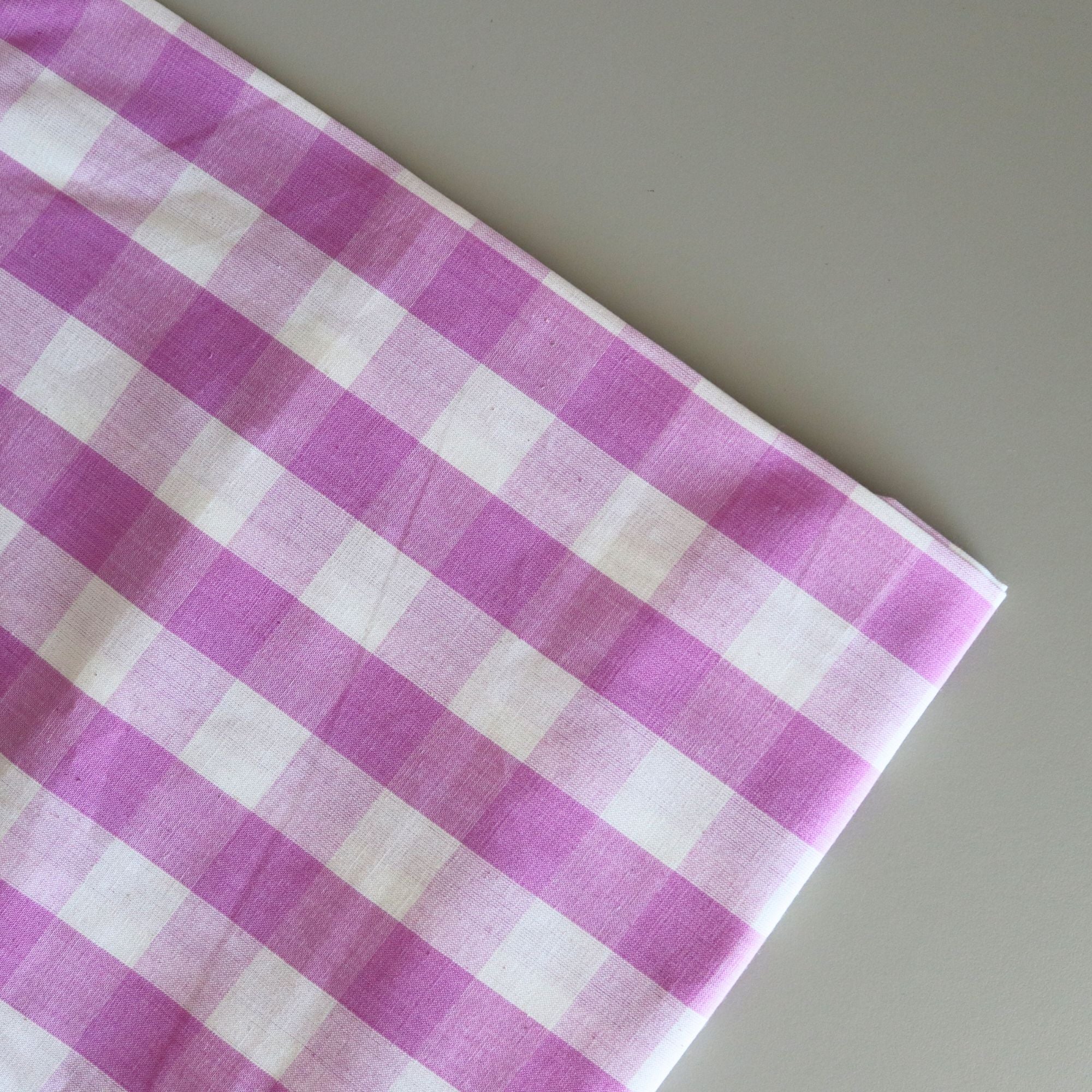 Purple and white checkered fabric on a gray background