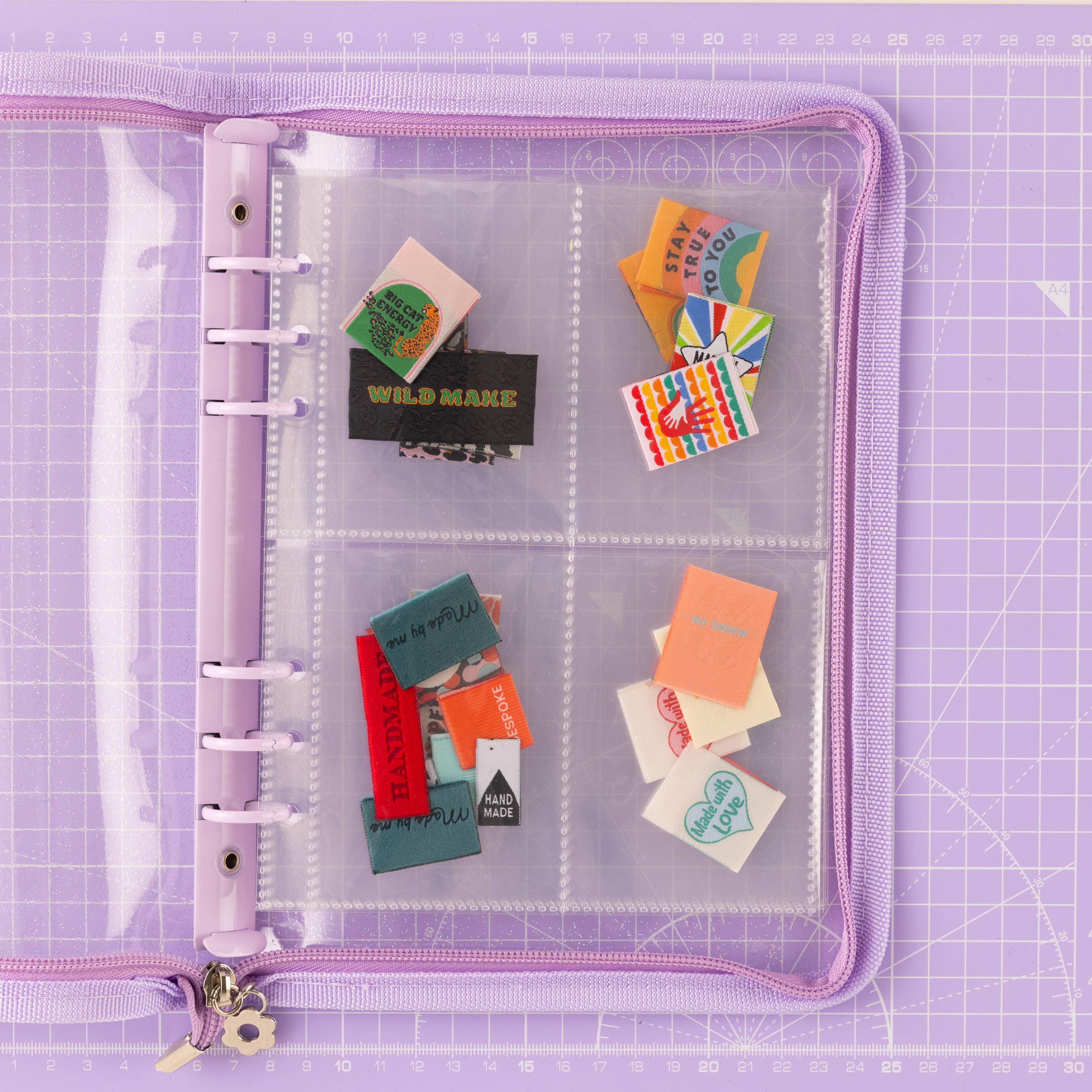 Clear Purple trimmed folder, with labels stashed inside the wallet. The folder is laying on a purple cutting mat.