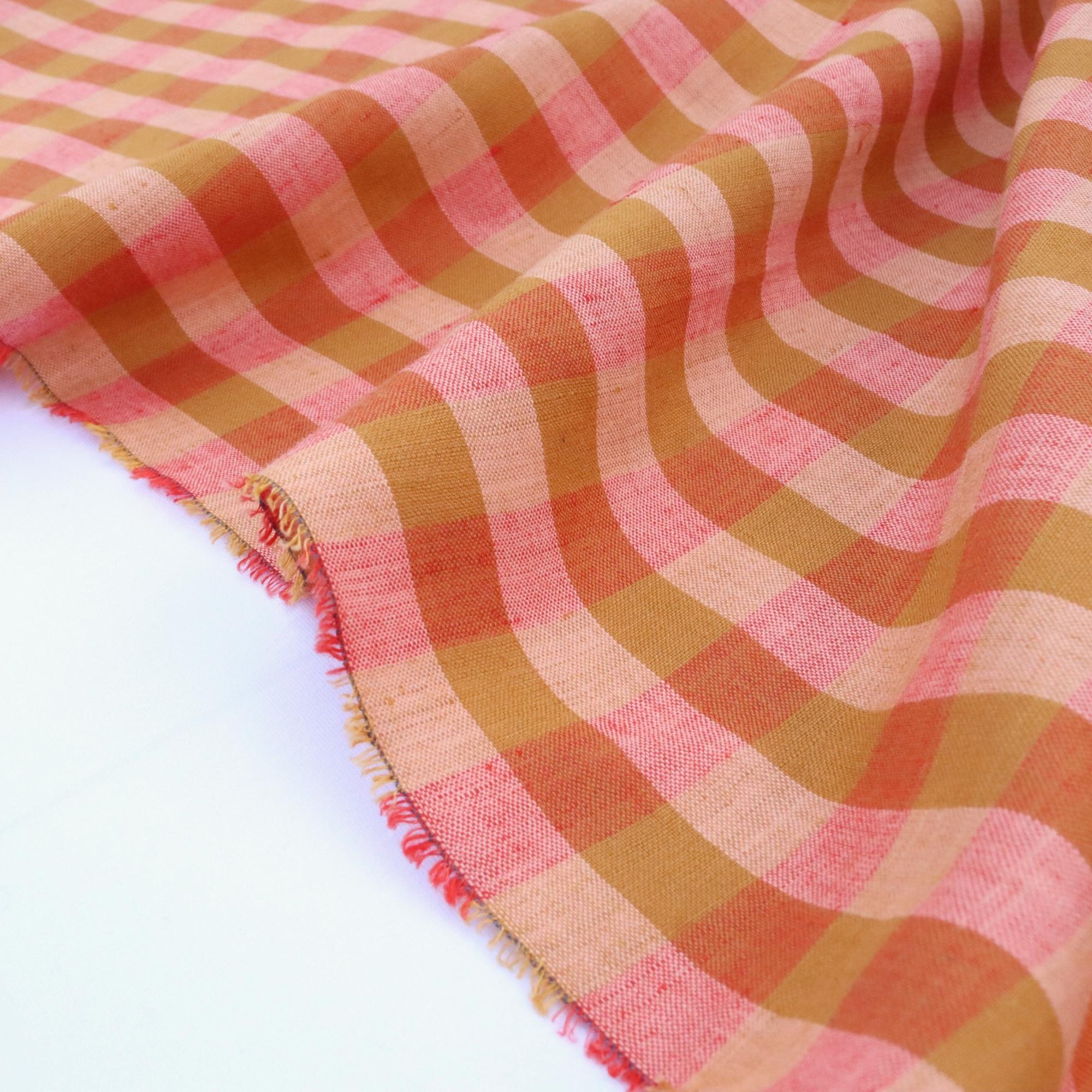 Checkered fabric with light and dark orange pattern on a white background