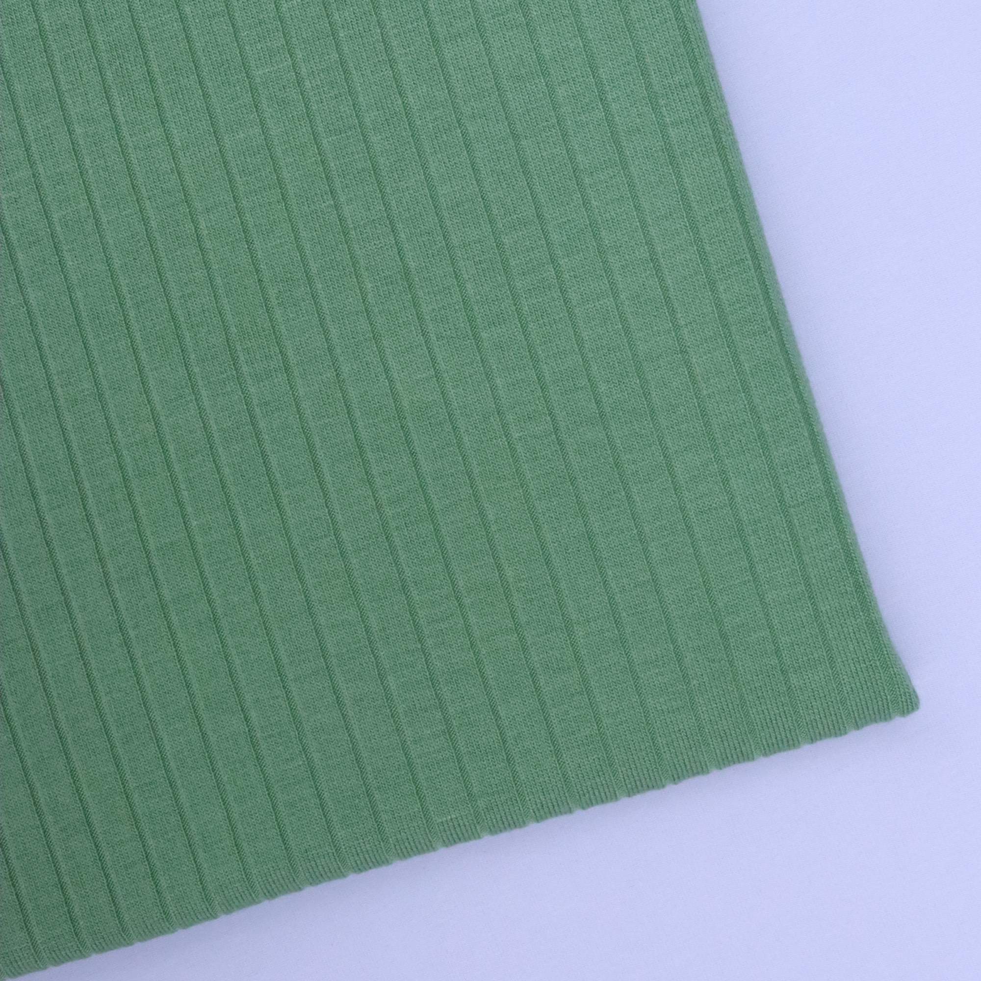 Close-up of green ribbed fabric on a white background