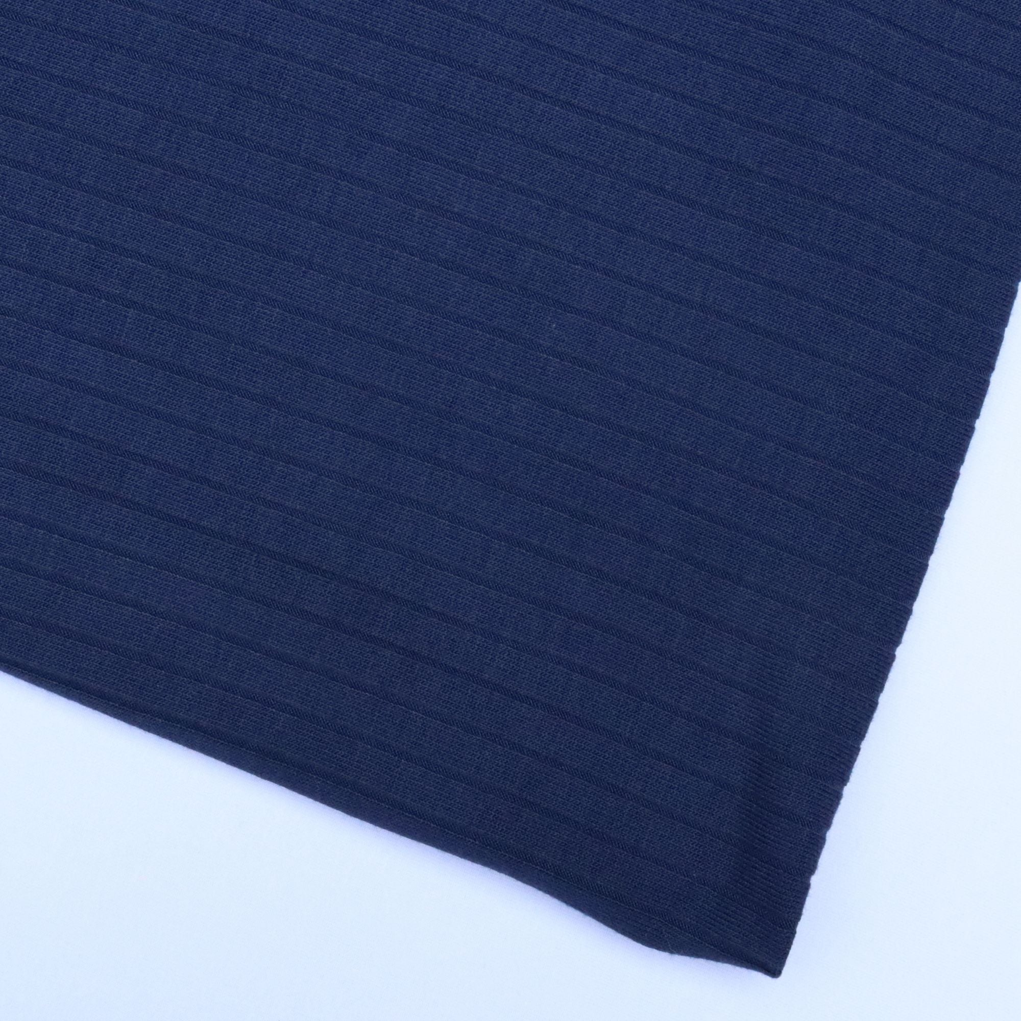 Close-up of dark blue fabric with a textured pattern on a white background