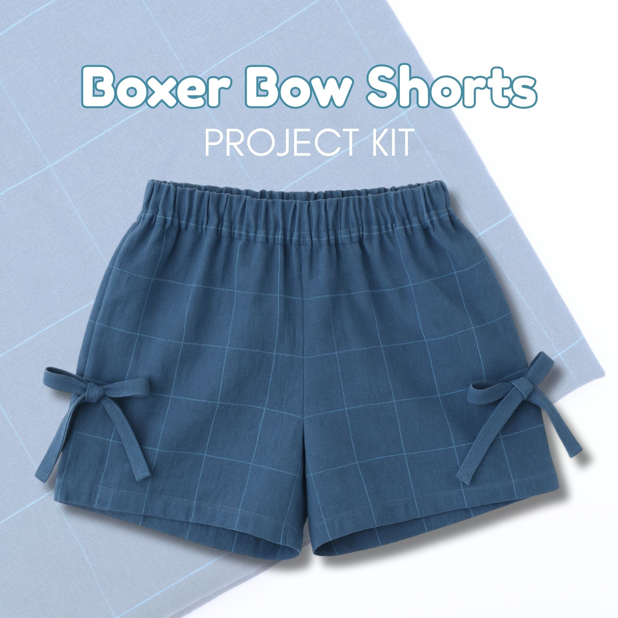 Blue boxer bow shorts on a light blue grid background with text &