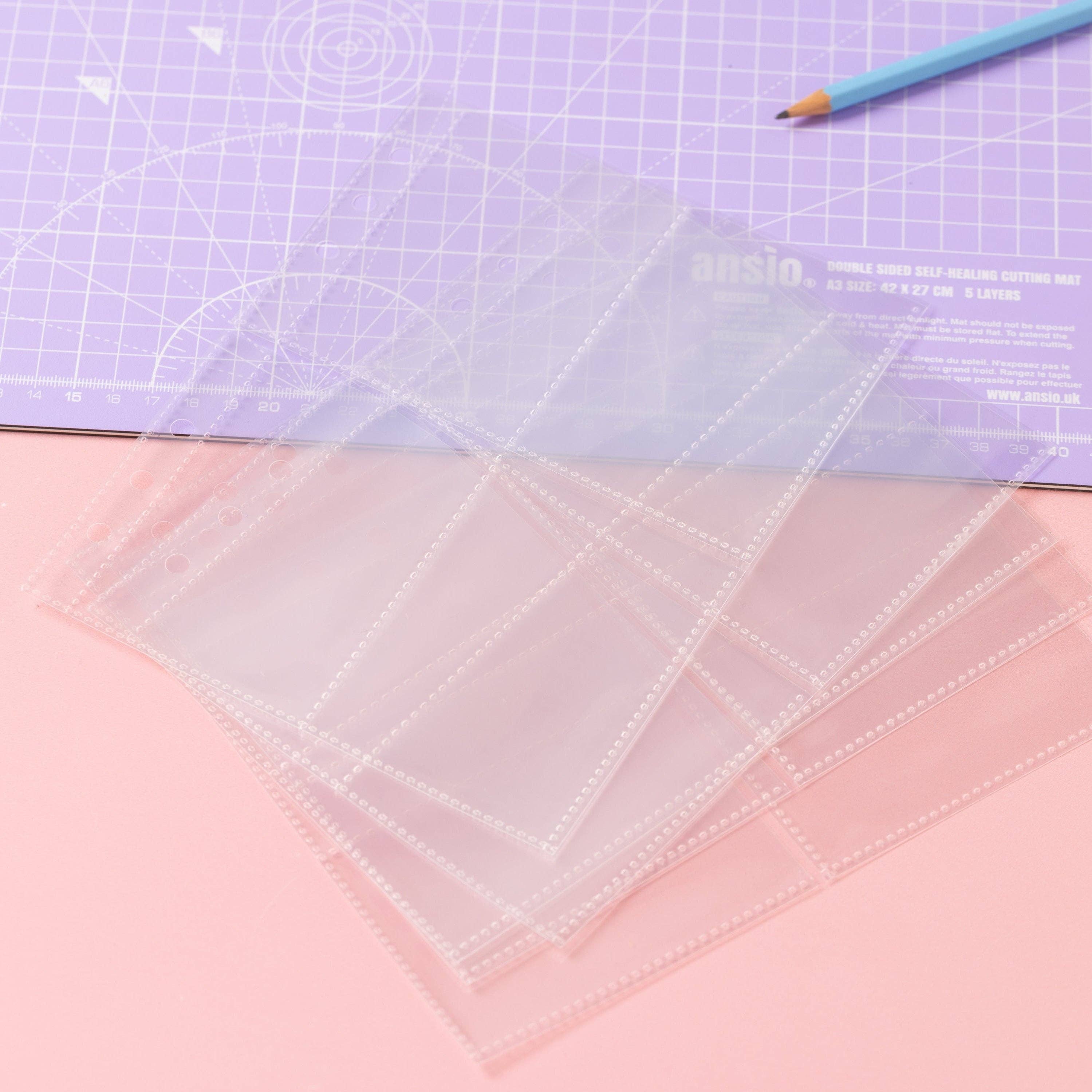 Clear plastic sheets for the sewing label stash folder laid out on the sewing table.
