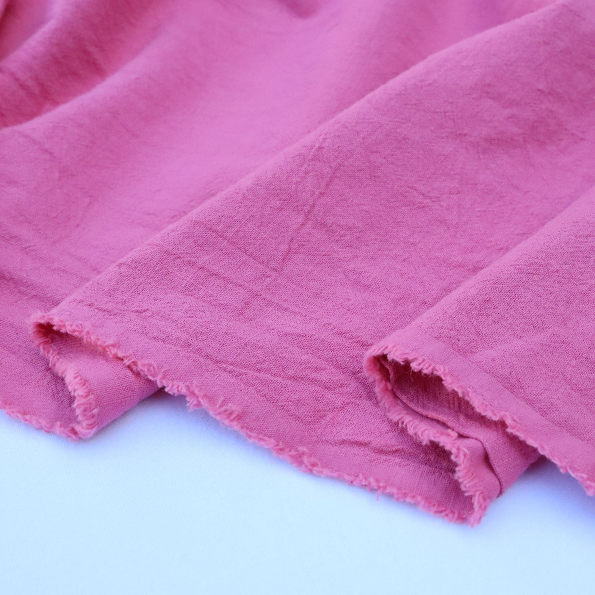 Close-up of pink fabric with a soft texture on a light blue background