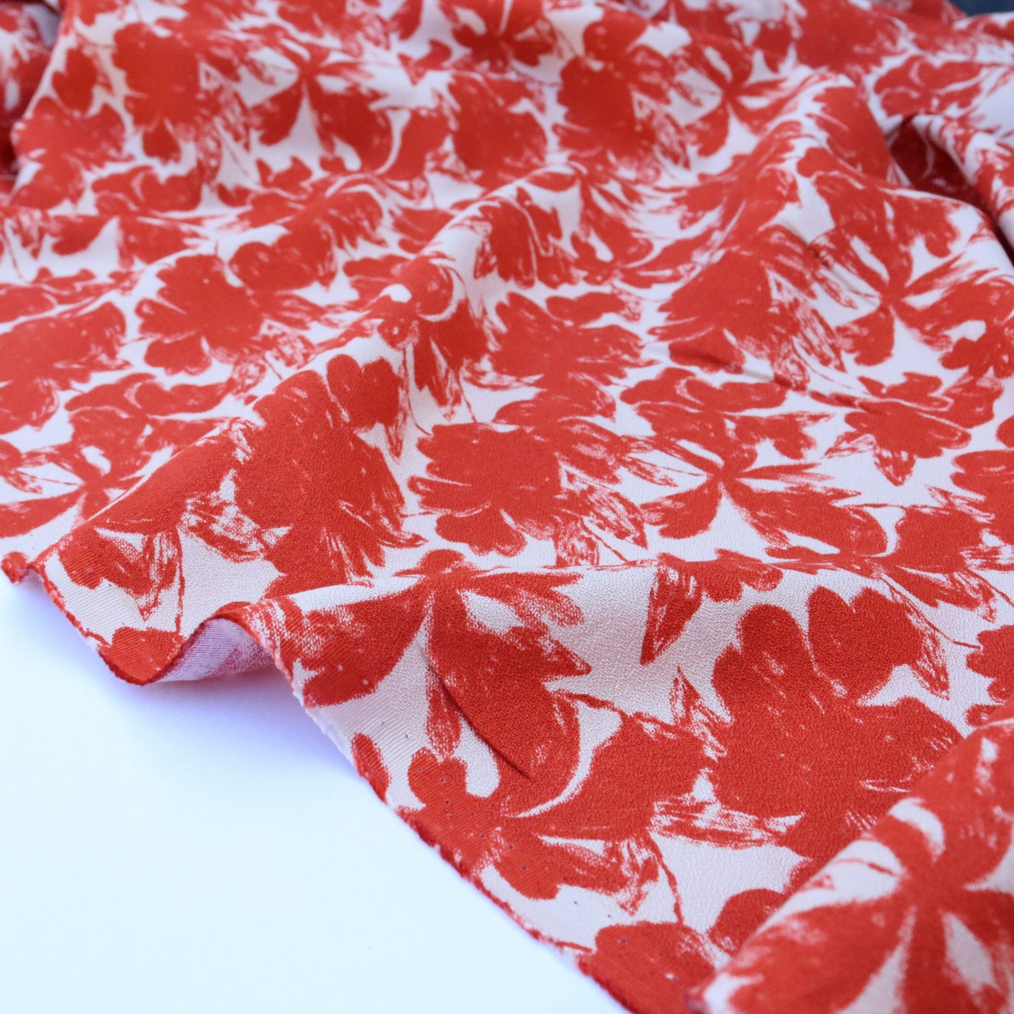 Red floral patterned fabric on a white background