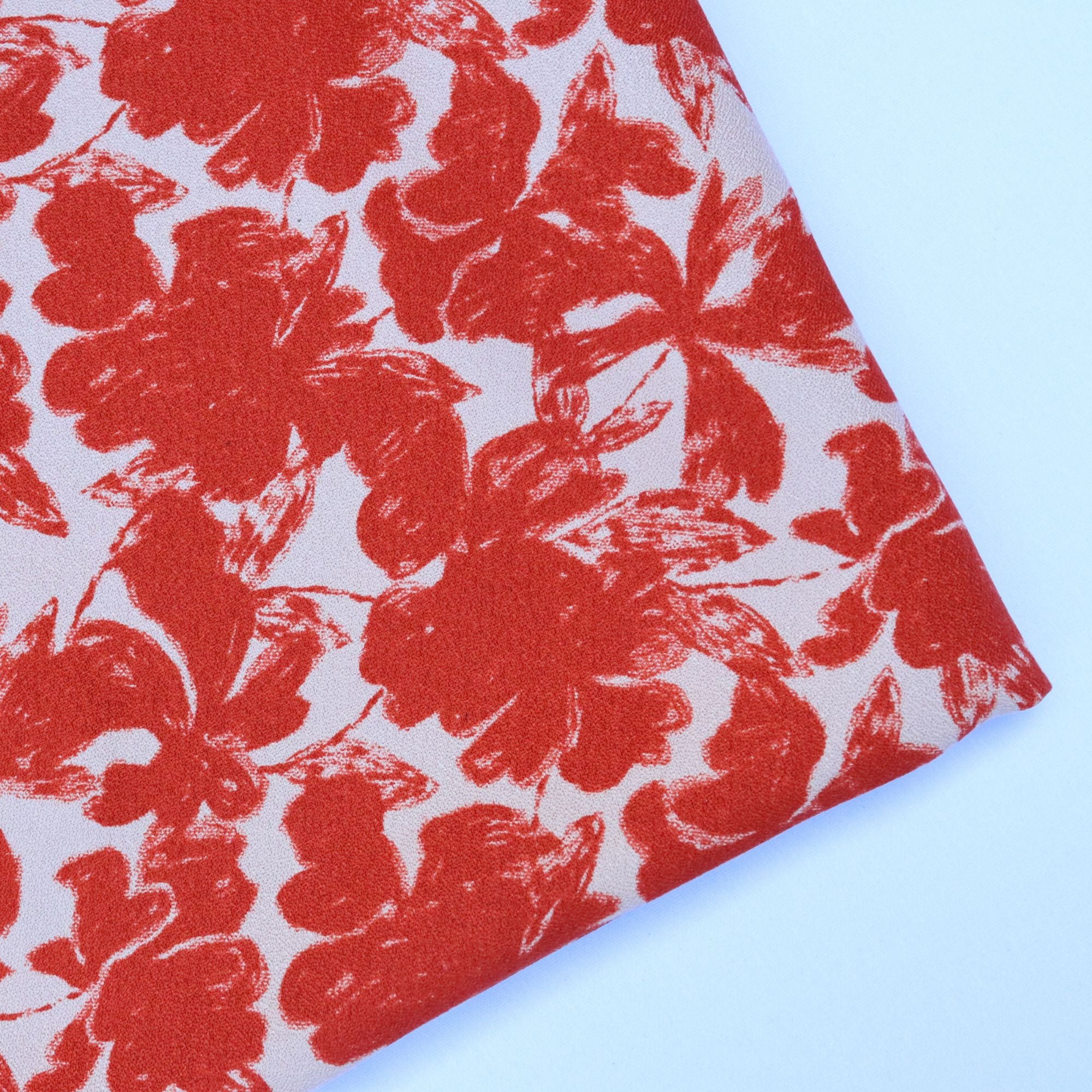 Red floral pattern on a white fabric against a light blue background