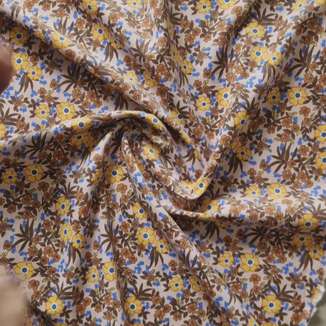 video of a baby needlecord in yellows and browns moving around, showing the close up of the design and movement
