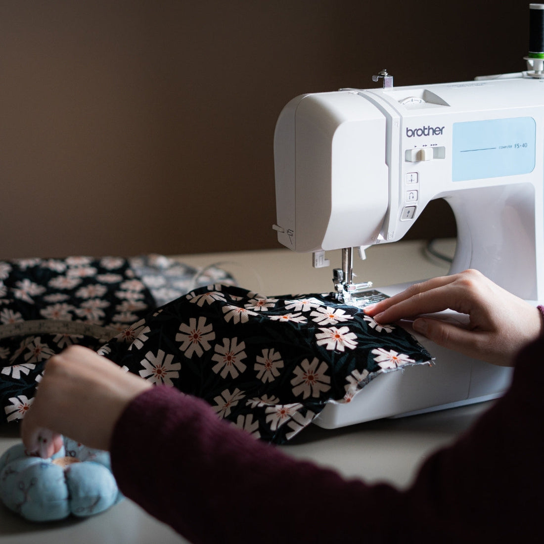 Sewing Machine feeding through a Needlecord Cotton Fabric and a Pin Cushion on the side