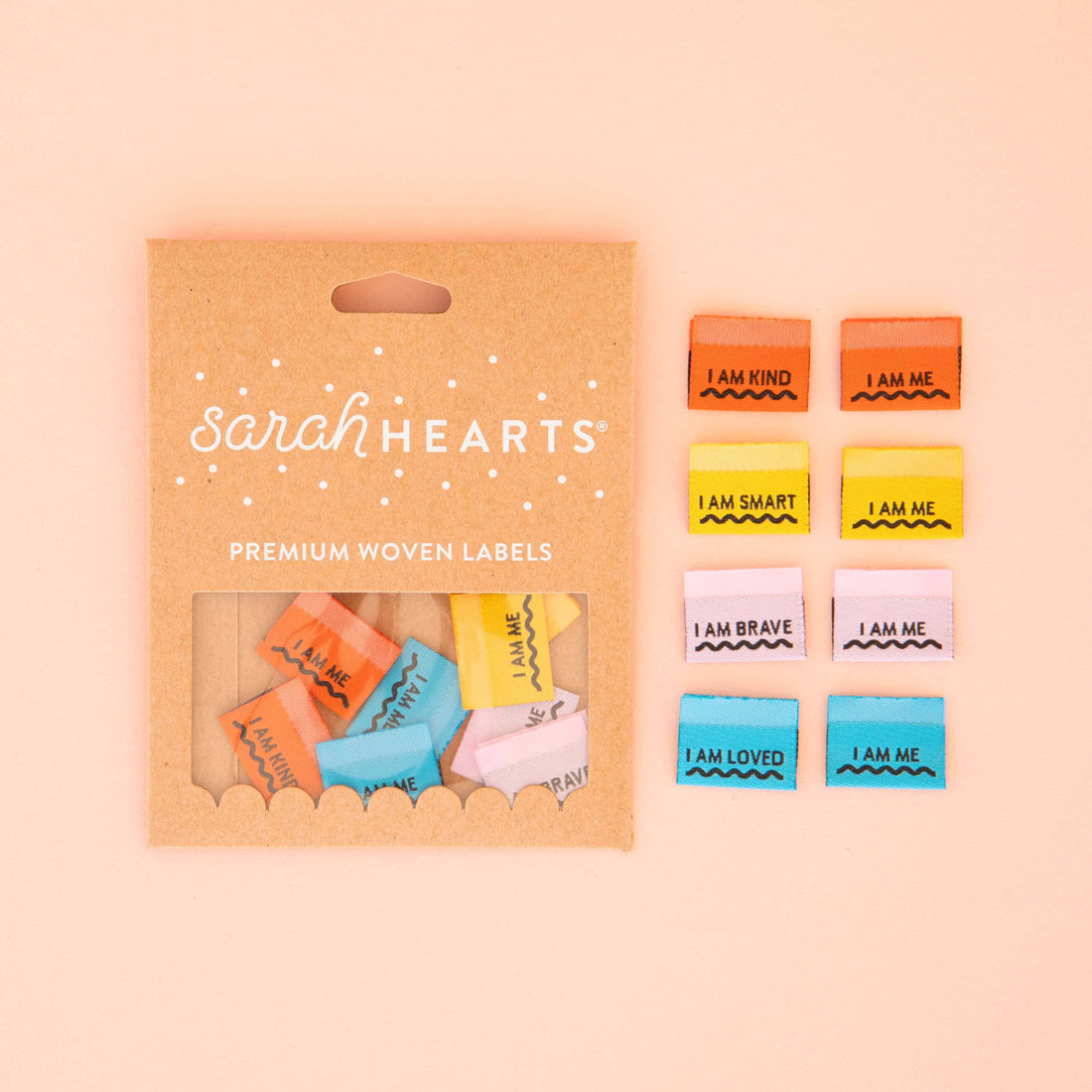 A colourful range of sew in labels, laid out in colour order with different affirmations written on them. &