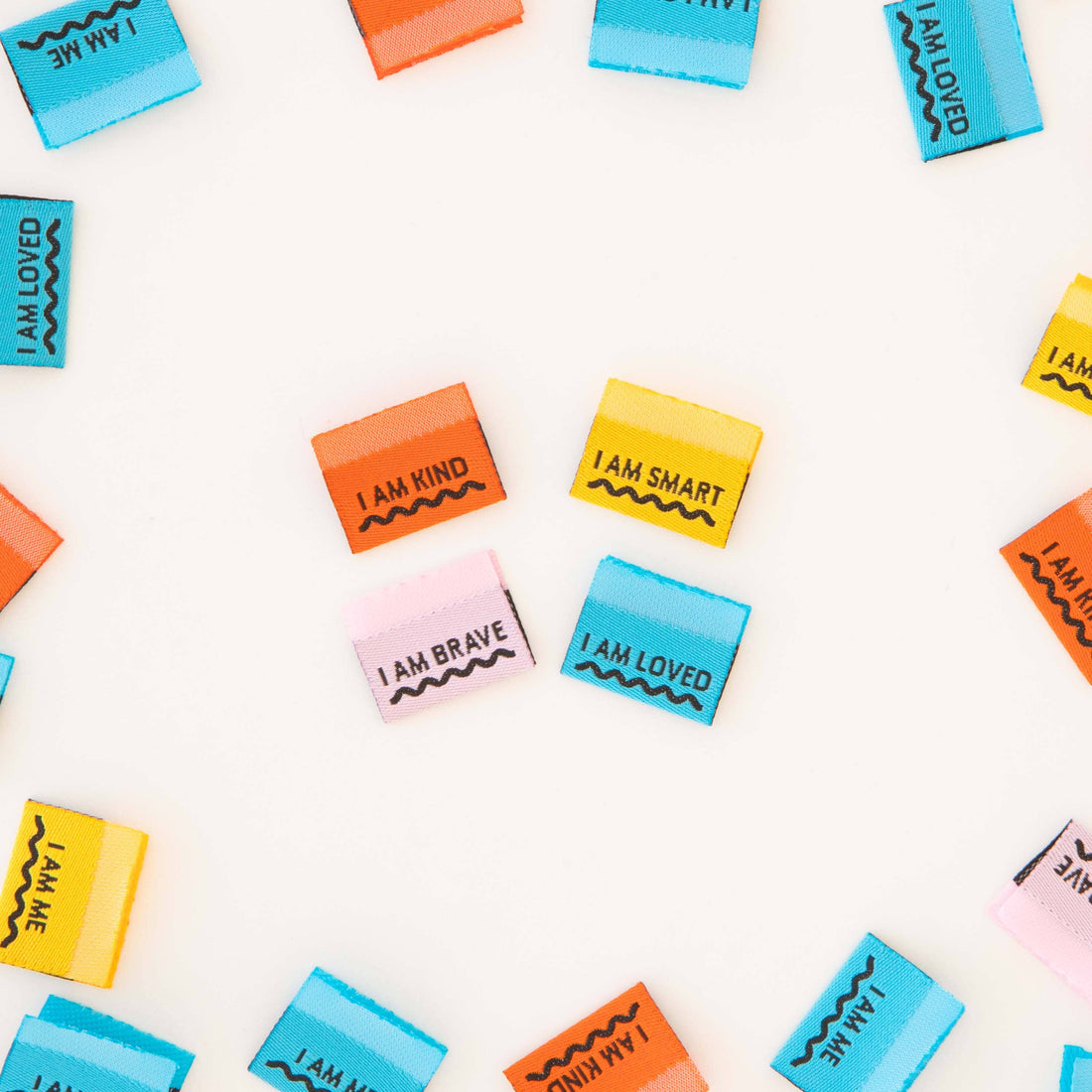 Various colored sewing labels with positive affirmations such as &