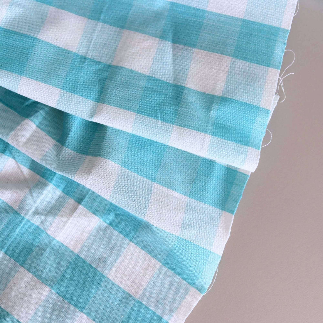 Close up of the Aqua Blue and White Gingham Large Check Fabric, laid out on the table