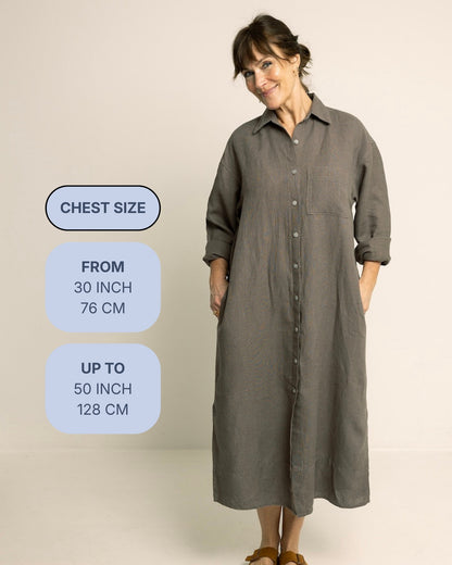 A woman modeling a long, loose button-front shirt dress in a muted gray-green tone against a plain light beige studio background. On the left side, rounded blue text boxes show chest size information: from 30 inch (76 cm) up to 50 inch (128 cm).