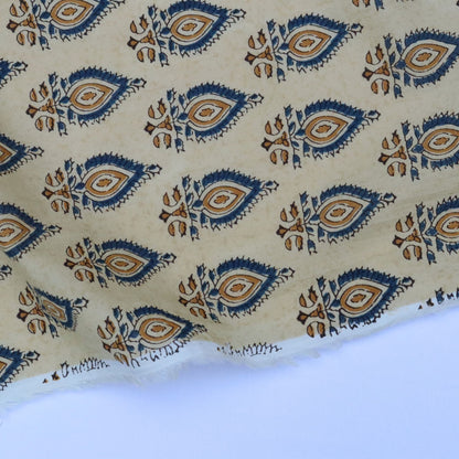 Patterned fabric with blue and brown designs on a beige background