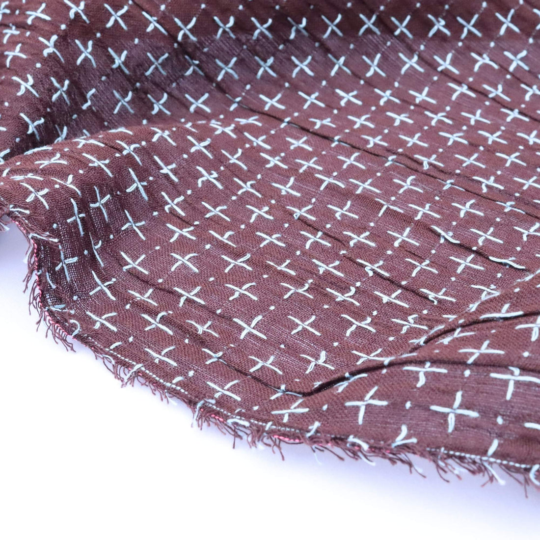 Brown fabric with white cross pattern on a white background