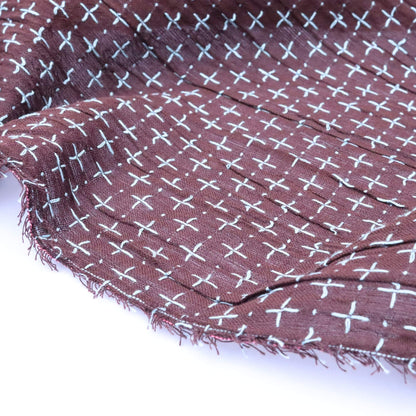 Brown fabric with white cross pattern on a white background