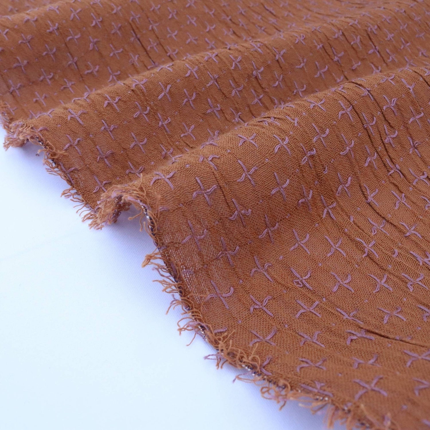 Brown fabric with a subtle pattern on a white background