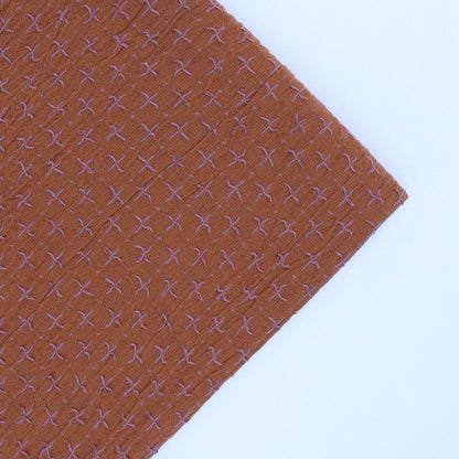 Brown fabric with a subtle pattern on a white background