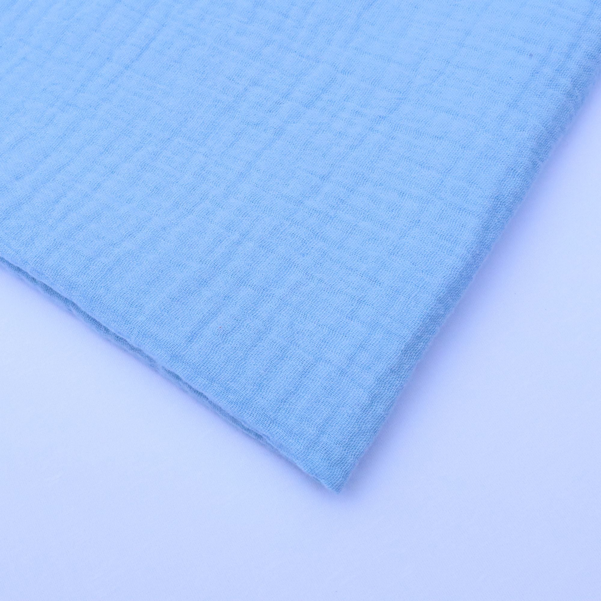 Close-up of light blue textured fabric on a matching background