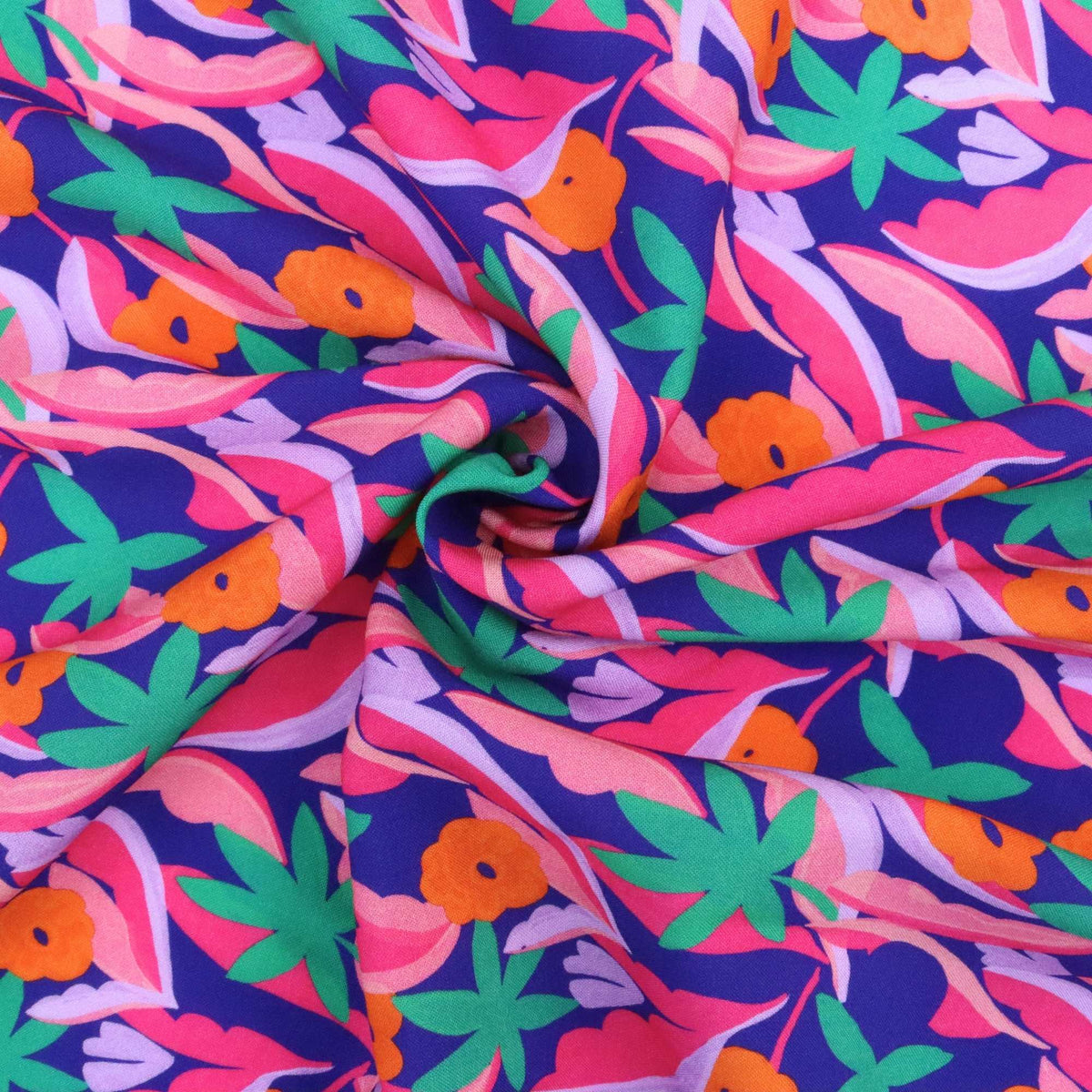 Colorful fabric with a tropical pattern featuring leaves and flowers on a blue background.