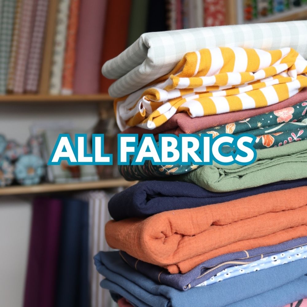 Stack of colourful sustainable fabrics including gingham, stripes, florals and solids – shop eco-friendly fabrics at Sew Eco Fabrics