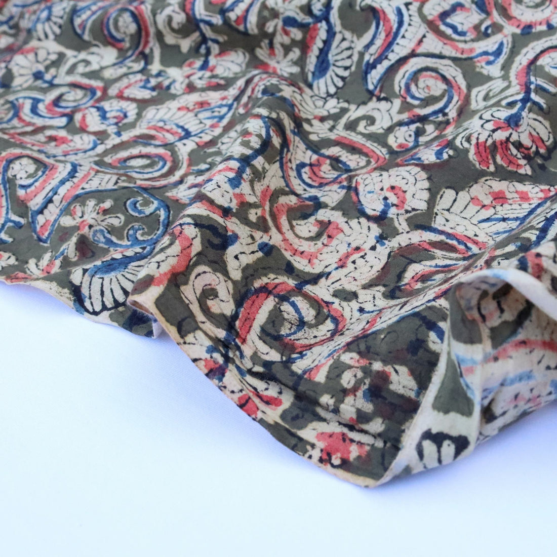 Patterned fabric with red, blue, and beige design on a white background