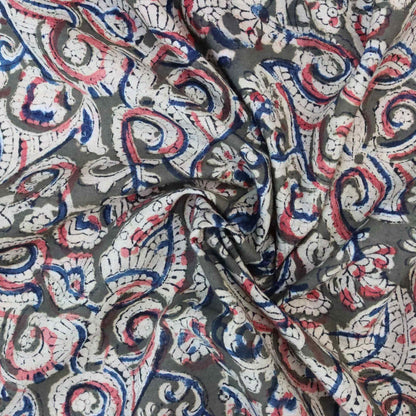 Close-up of patterned fabric with red, blue, and white swirls on a gray background