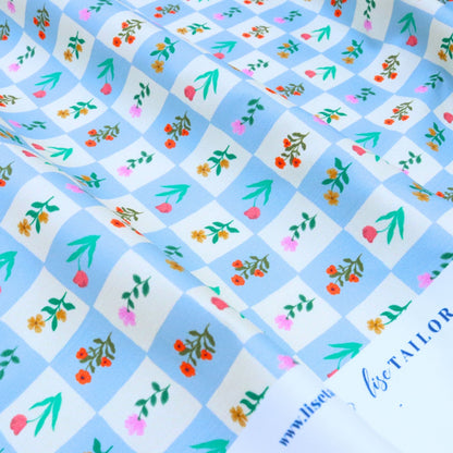 Floral patterned fabric with a checkered background and visible brand name.