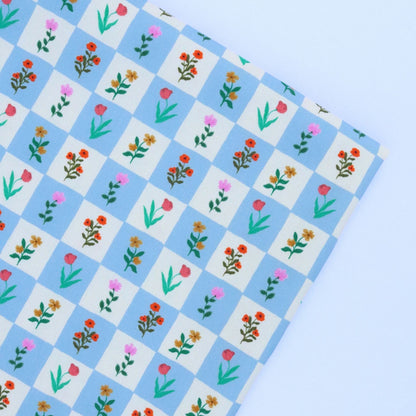 Checkered paper with floral pattern on a light blue background
