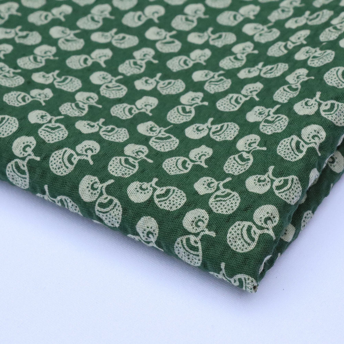 Green fabric with white pattern on a white background
