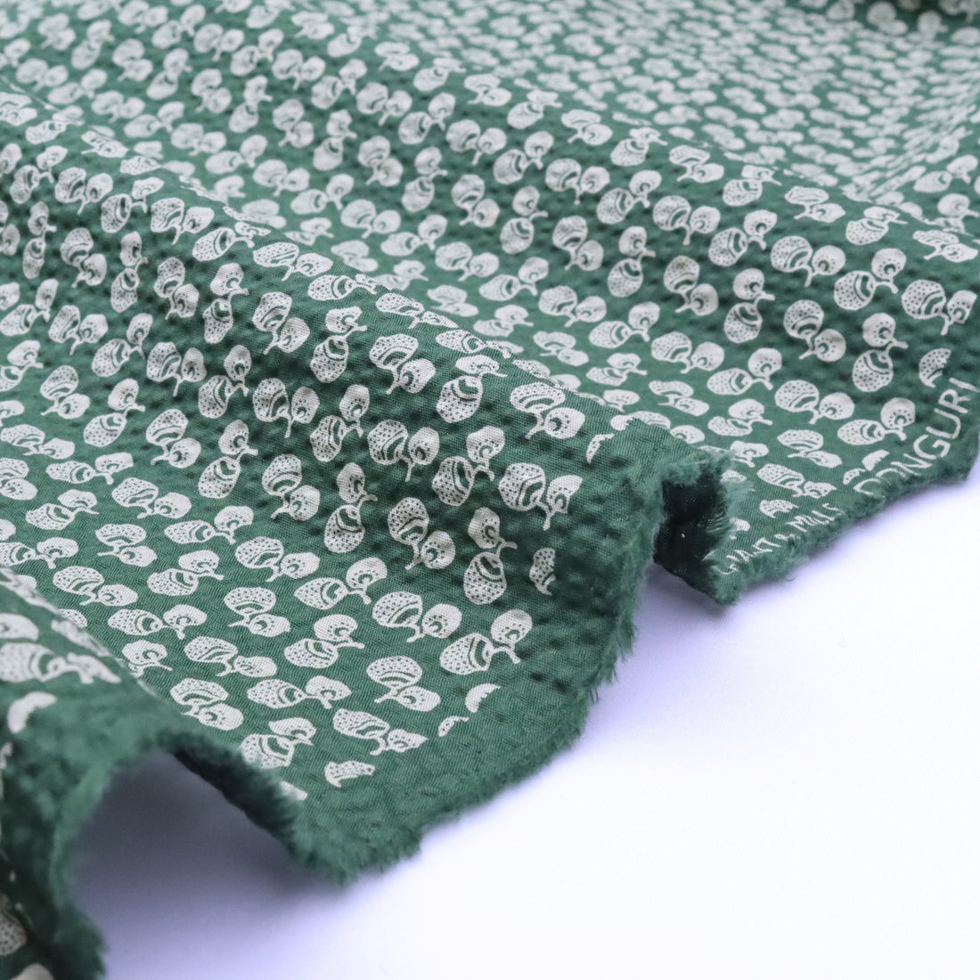 Green fabric with white pattern on a white background