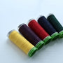 set of colourful gutermann threads lined up, showing the recycled polyester ends