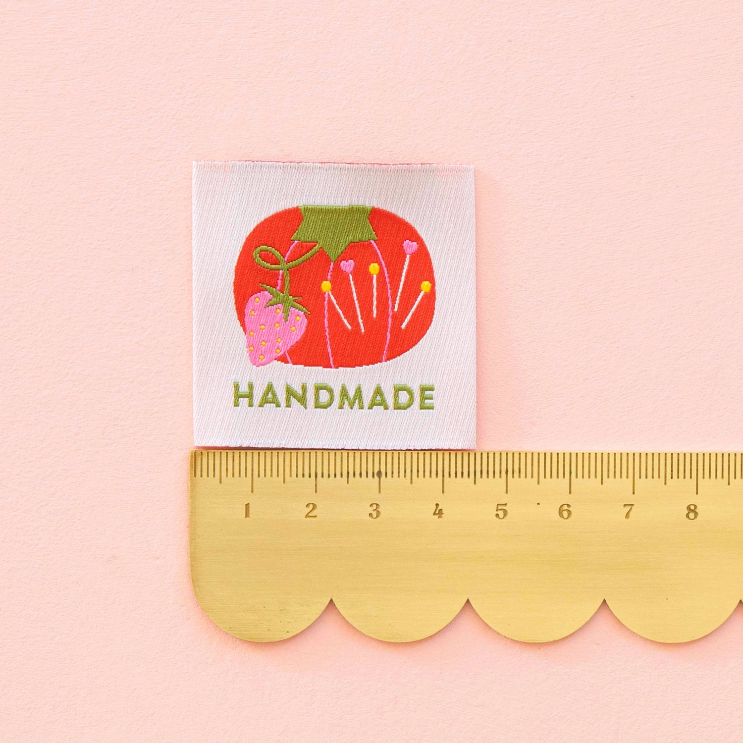 Sewing Label saying &quot;Handmade&quot; with a tomato pin cushion design on white background. Measured with a ruler 4.5cm.