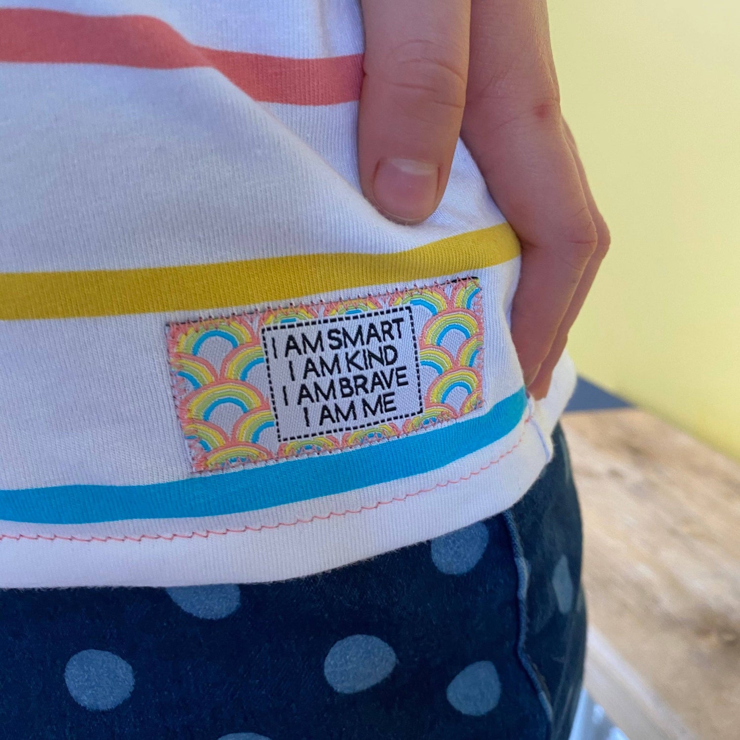 Close up of the Sew in Woven Label, stitched in to  as stripey shirt. 