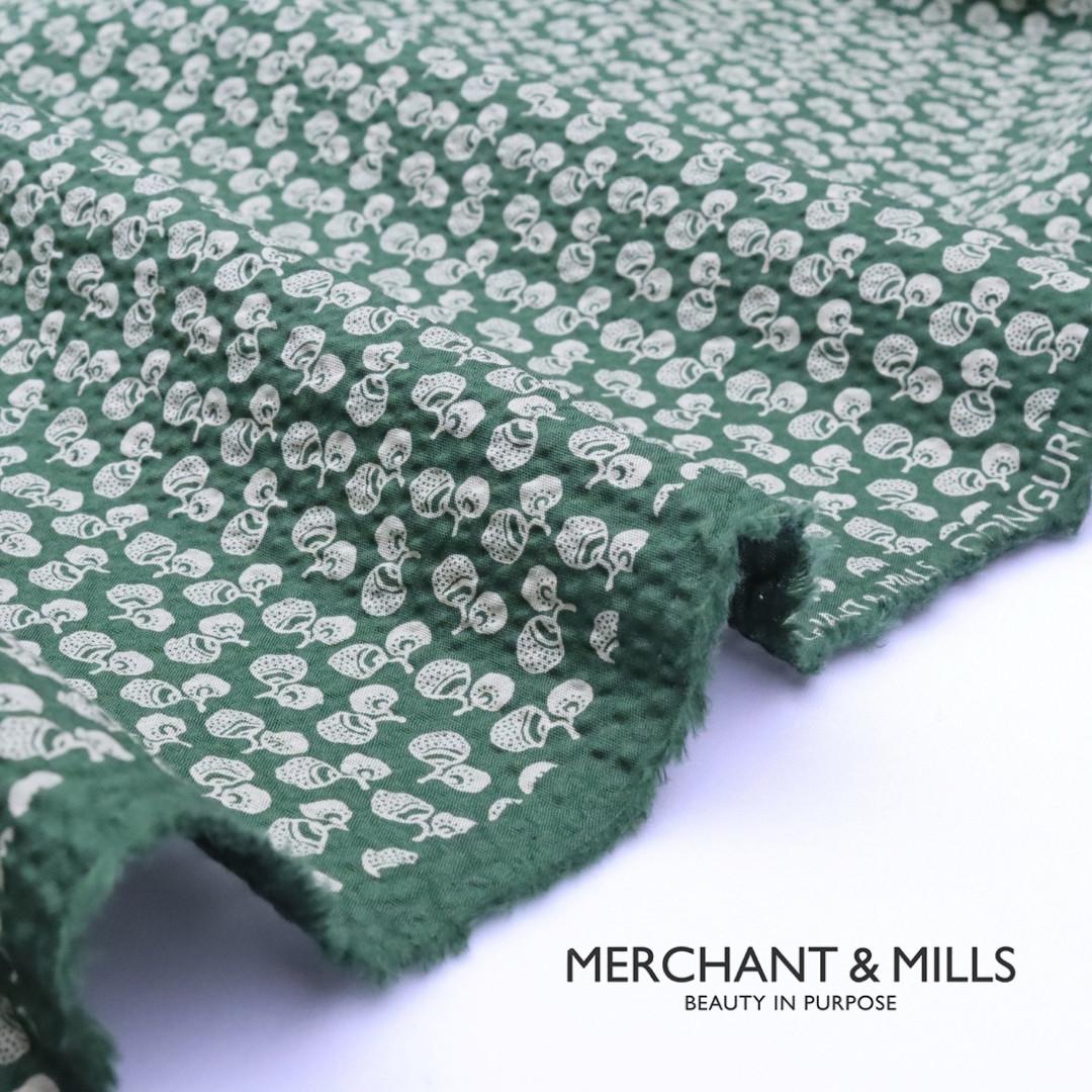 Green fabric with white pattern on a white background, featuring the Merchant & Mills logo.