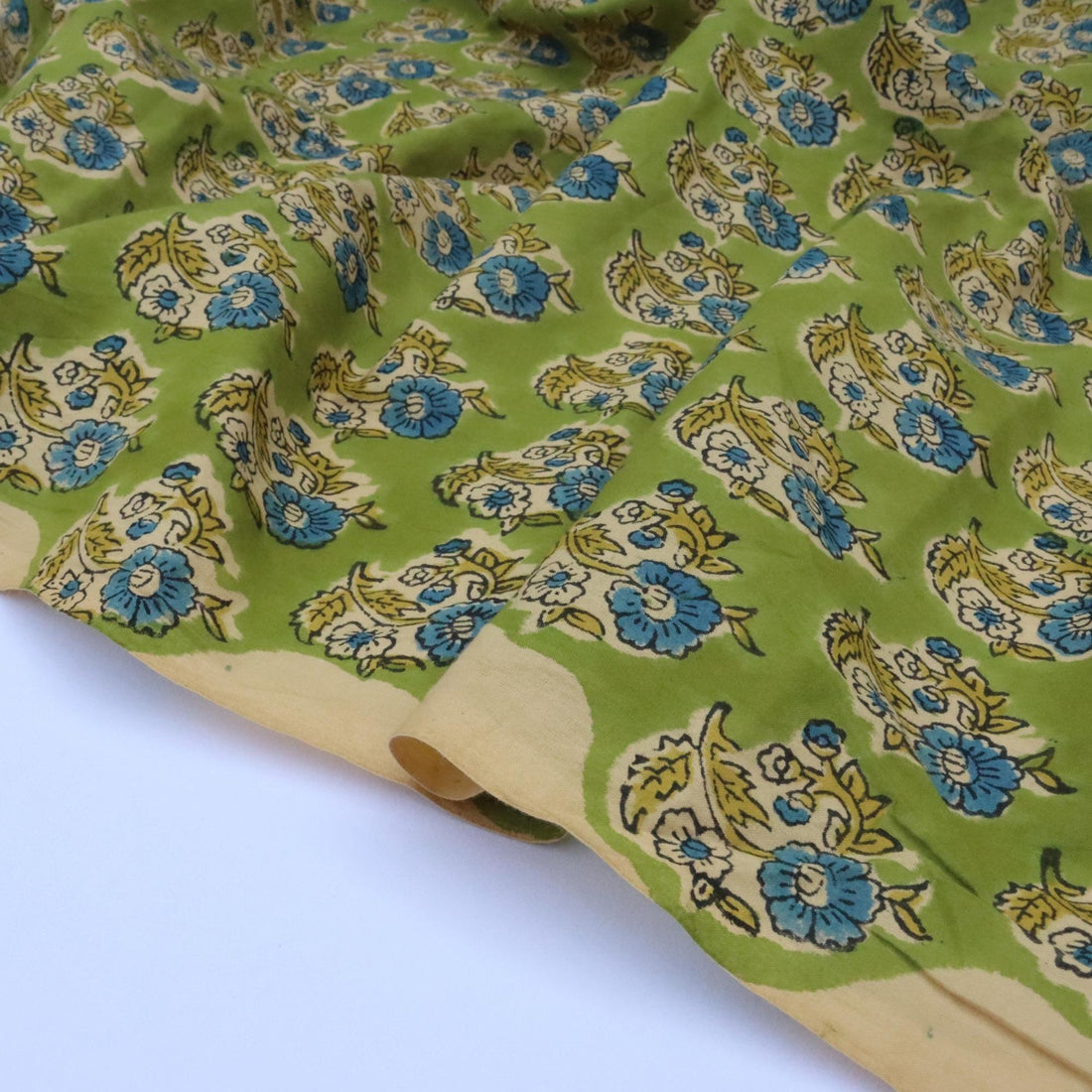 Green fabric with floral pattern on a white background