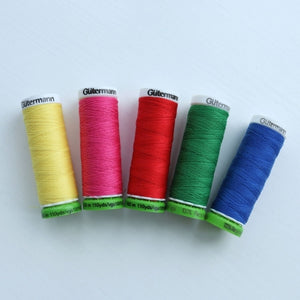 colourful spools of thread laid out on a white background